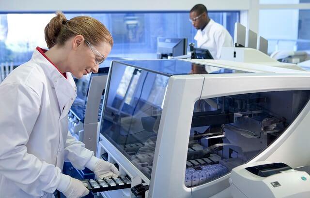 A clinician operating a Leica Biosystems IHC instrument in the context of companion diagnostics